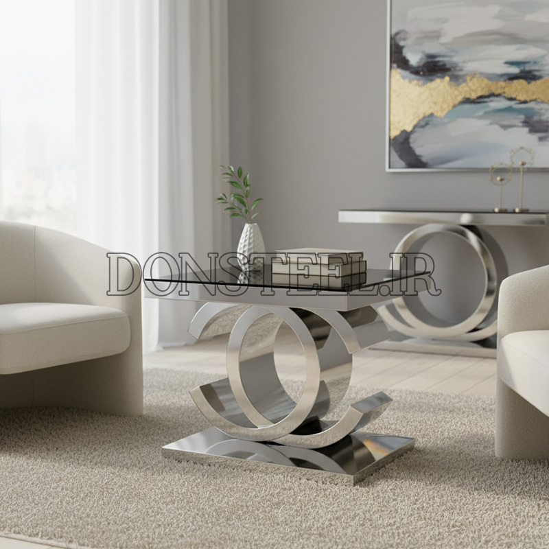 میز عسلی استیل مدل شنل 1 میز عسلی استیل نقره ای مدل شنل با رویه شیشه شفاف، ست شده با کنسول در چیدمان اتاق
